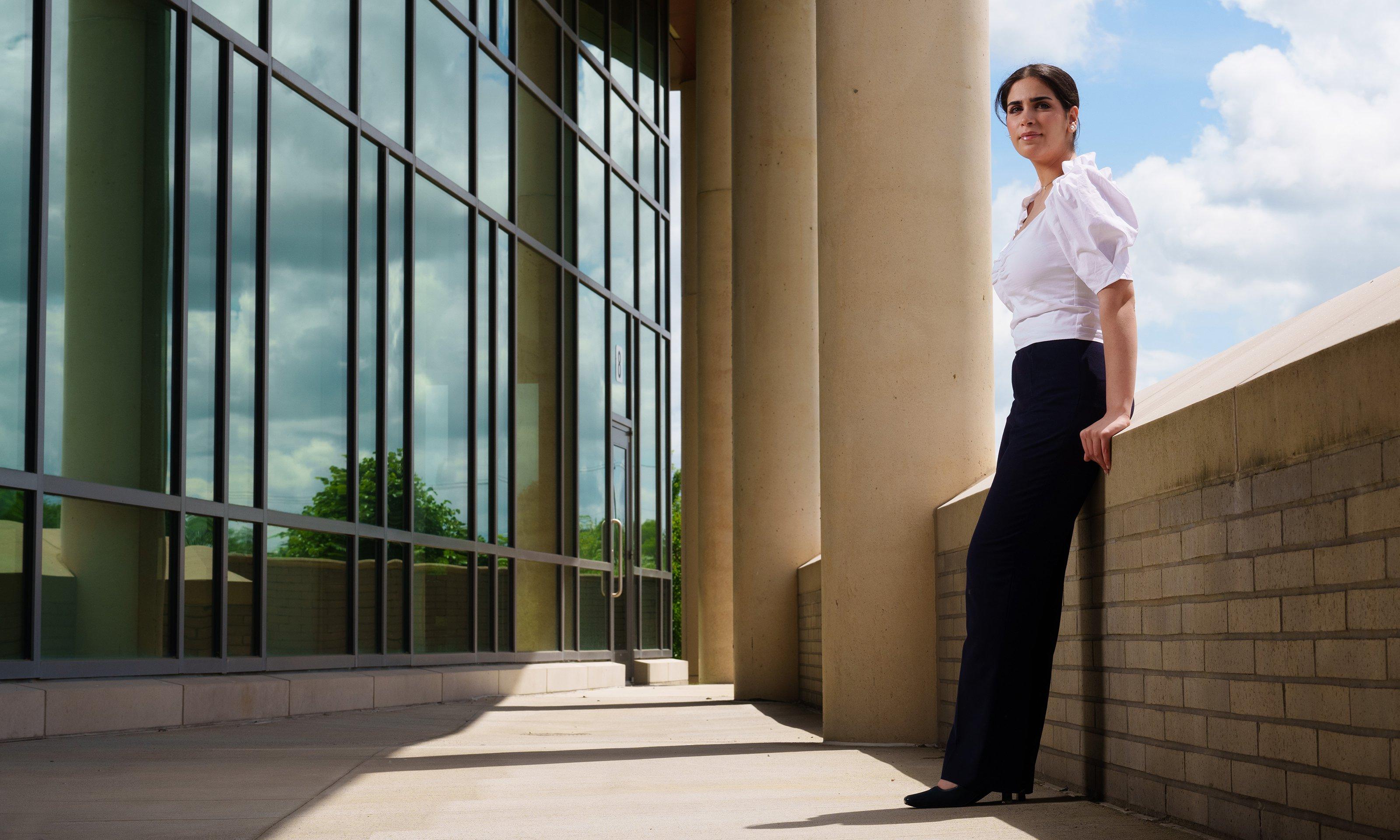 A student leaning on a wall outside